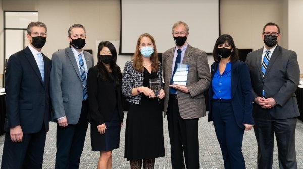 Two faculty members who won teaching awards stand next to President 曼 and Board Chair Megan Rydecki.